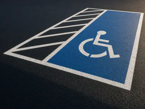 Accessible parking stall striping on freshly sealed black asphalt